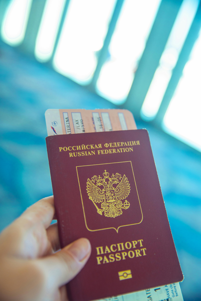 Generic passport held near an airport window